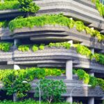 concrete building with green plants covering each floor.