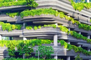 concrete building with green plants covering each floor.